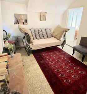 uma sala de estar com um sofá e um tapete vermelho em Casa Via Orsini Isolabona Liguria Italy Sleeps 5 em Isolabona