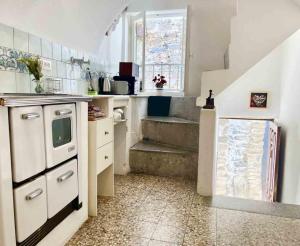een keuken met een wastafel, een fornuis en een trap bij Casa Via Orsini Isolabona Liguria Italy Sleeps 5 in Isolabona
