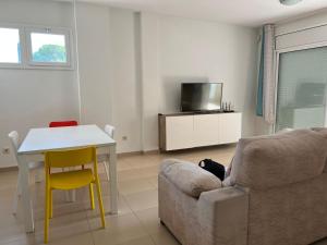 a living room with a couch and a table and a tv at 2 Avinguda Santa Clotilde in Lloret de Mar