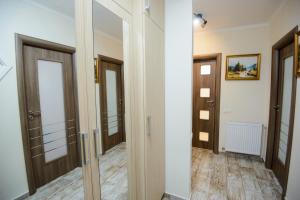um corredor com portas e espelhos num quarto em Apartament Eliza em Poiana Brasov