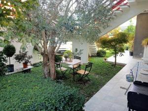 a patio with a tree and a table and chairs at casa Guanita in Uzzano