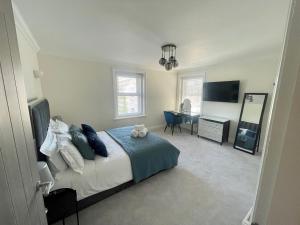 a bedroom with a bed and a desk in it at Exquisite apartment, stone throw from the beach in Bournemouth