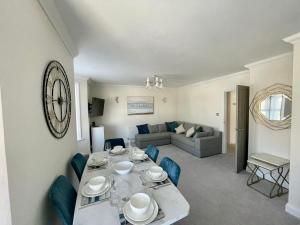 a dining room and living room with a table and chairs at Exquisite apartment, stone throw from the beach in Bournemouth