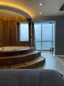 Großes Zimmer mit einer Badewanne und einem großen Fenster. in der Unterkunft Mira Hotel Boutique in Izmir