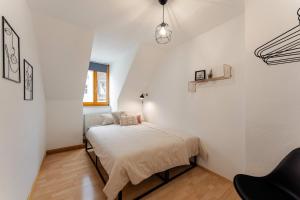 1 dormitorio pequeño con 1 cama y 1 silla en Altstadt Apartments zentral am Rathaus, en Augsburg