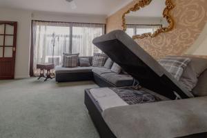 uma sala de estar com um sofá e um espelho em Palm Bay's Luxury Bungalow - Self Check In & Parking em Margate