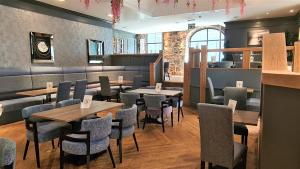 a dining room with tables and chairs in a restaurant at Royal Athenaeum Suites in Aberdeen