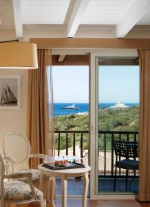 a room with a balcony with a view of the ocean at CPH | Pevero Hotel in Porto Cervo