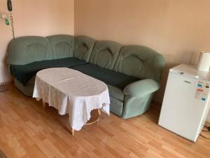 a green couch with a table in a room at Hotel Rade 2 in Vratsa