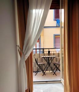 een kamer met een balkon met een tafel en een raam bij IlGirasoleApartment in Napels
