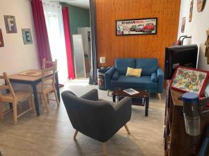 uma sala de estar com um sofá azul e uma mesa em Studio tout équipé centre ville Dol de Bretagne em Dol-de-Bretagne
