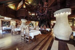 two large white vases in a restaurant with tables at Hotel Kasztel in Rzezawa