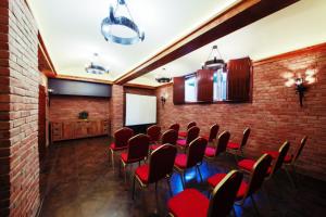 a conference room with red chairs and a brick wall at Hotel Kasztel in Rzezawa