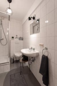 La salle de bains blanche est pourvue d'un lavabo et de toilettes. dans l'établissement Altstadt Apartments zentral am Rathaus, à Augsbourg