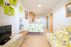 - un salon avec un canapé et une chaise dans l'établissement Global Properties, Apartamento con gran terraza y piscina, à Canet d'En Berenguer