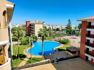 - une vue sur la piscine depuis un bâtiment dans l'établissement Global Properties, Apartamento con gran terraza y piscina, à Canet d'En Berenguer