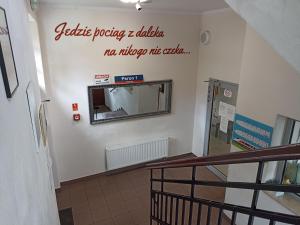 un couloir avec un panneau sur un mur avec un miroir dans l'établissement Open Tours, à Ełk