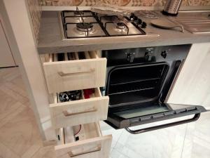 a stove in a kitchen with wooden drawers at IlGirasoleApartment in Naples