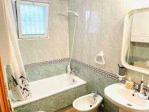 een badkamer met een wastafel, een bad en een toilet bij charming apartment in Torrevieja