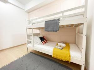 Encorp Strand Lovely 2BR Condo at Kota Damansara في بيتالينغ جايا: سرير بطابقين أبيض مع بطانية صفراء عليه