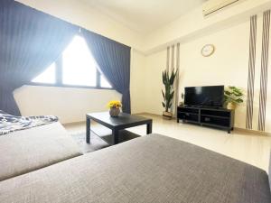 een slaapkamer met een bed en een flatscreen-tv bij Encorp Strand Lovely 2BR Condo at Kota Damansara in Petaling Jaya