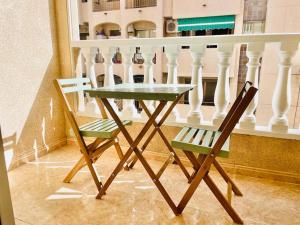 een tafel en 2 stoelen naast een balkon bij charming apartment in Torrevieja