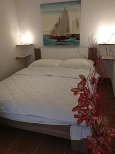 a bedroom with a bed with a painting of a boat at Apartments Topić in Privlaka