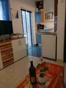 a kitchen with a bottle of wine on a table at Apartments Topić in Privlaka