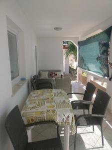 a dining room with a table and chairs and a television at Apartments Topić in Privlaka