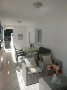 un soggiorno con divano, sedie e tavolo di Apartments Topić a Privlaka (Brevilacqua)