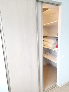 a white closet with a glass door and a closetyss at Pigeon apartment in Kuldīga