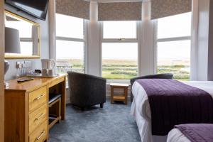 Habitación de hotel con escritorio, cama y ventana en Furzedown Hotel, en Great Yarmouth