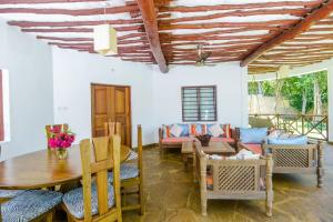 Villa PundaMilia Private Pool free wifi secure في Kwale: غرفة معيشة مع طاولة وأريكة