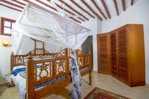 una camera con letto in legno a baldacchino di Villa PundaMilia Private Pool free wifi secure a Kwale