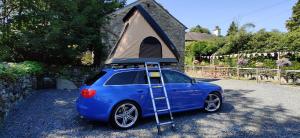 a blue car with a tent on top of it at Mallory Rooftop Tent Hire - from ElectricExplorers in Hawkshead