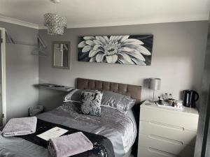 een slaapkamer met een bed met een bloemschilderij aan de muur bij No1 Guest House in Stamford