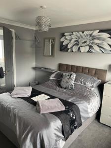 a bedroom with a large bed with a flower picture on the wall at No1 Guest House in Stamford