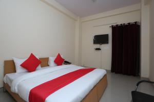 a bedroom with a large bed with red pillows at Mannat Residency in Ghaziabad