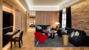 a living room with a black couch and a red chair at Monument Hotel in Barcelona