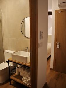 a bathroom with a sink and a mirror and a toilet at PATE'O Hostel & Suites in Ovar