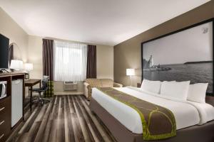 サーニアにあるSuper 8 by Wyndham Sarnia ONの大きなベッドとデスクが備わるホテルルームです。