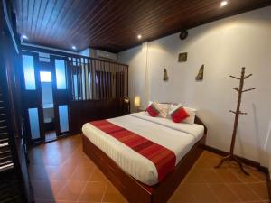 a bedroom with a bed with a cross on the wall at Vangsavath Hotel in Luang Prabang