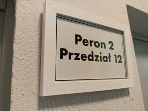 Un cartello su un muro con le parole perron proiettedkat di Open Tours a Ełk