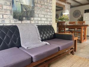 a purple couch in a living room with a brick wall at Ou Klipskuur Self-Catering Accommodation in Fraserburg