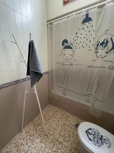 bagno con tenda per la doccia e servizi igienici di Sarah Kite II Vv, Room 2 a Playa del Burrero