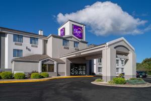 a hotel with a purple sign on top of it at Sleep Inn in Charleston