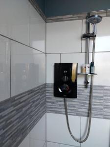 La salle de bains est pourvue d'une douche avec un tuyau. dans l'établissement Inviting 1-Bed Apartment in Herne Bay, à Herne Bay