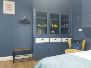 a bedroom with a blue wall with a cabinet and a chair at Inviting 1-Bed Apartment in Herne Bay in Herne Bay
