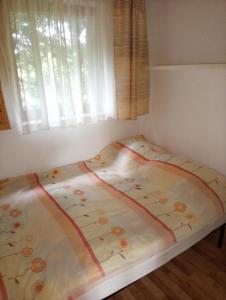 Bett in einem Zimmer mit Fenster in der Unterkunft Cztery Pory Roku - Domek 