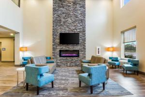 a lobby with chairs and a fireplace with a tv at MainStay Suites Winfield-Teays Valley in Hurricane